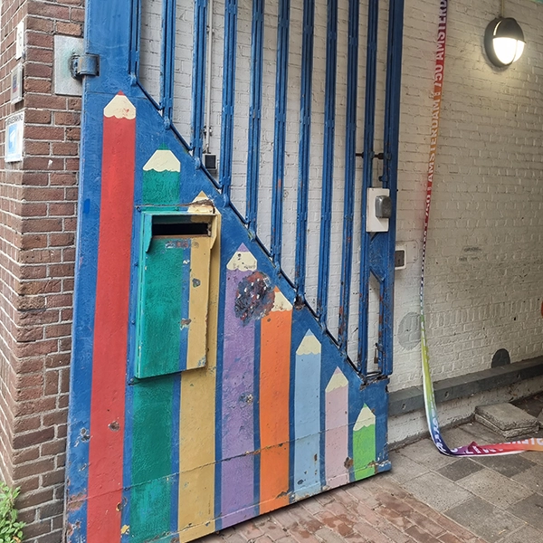 Beschadigde beschildering op een metalen hek in Amsterdam voor aanvang van het onderhoud
