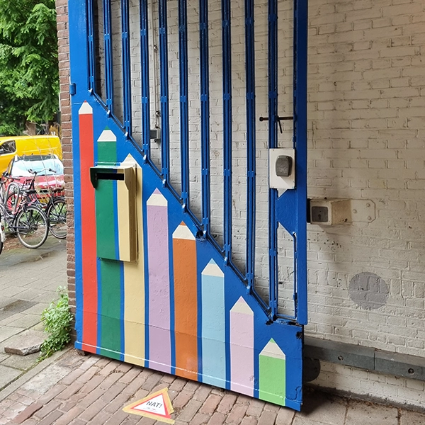 Het kleurrijke metalen hek in Amsterdam na afronding van het schilderwerk