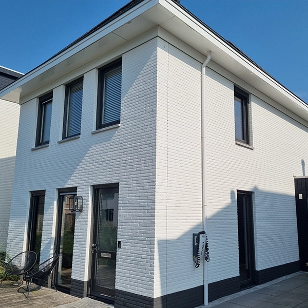Wit gesausde gevel van een van twee geschilderde panden in Almere