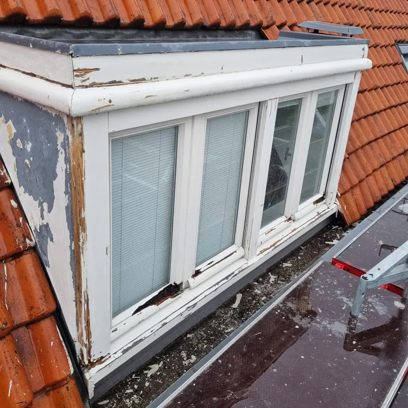 Dakkapel in Amsterdam met aangetast hout en afbladderende verf voor het herstel