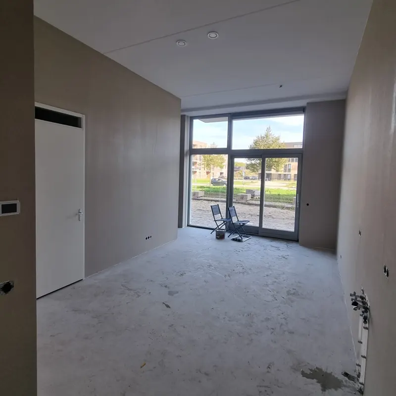 Overzicht van de ruimte in Dronten na het aanbrengen van vliesbehang en sauswerk aan de wanden